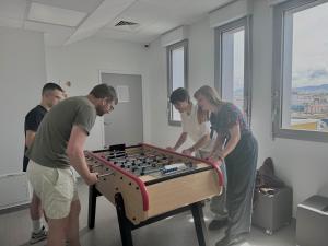 Un groupe de personnes autour d'une table avec une boule alimentaire dans l'établissement Auberge de jeunesse HI Clermont-Ferrand, à Clermont-Ferrand