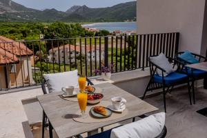 a table with food and drinks on a balcony at Hotel AQUILO in Petrovac na Moru