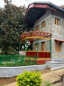 a building with a bench in front of it at Lilly's Valley Resort in Kodaikānāl