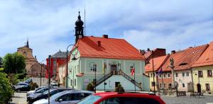 a building with a red roof in a city at Agroturystyka Zielony Domek - Apartament na wyłączność, slow life, staw, oswojone zwierzęta gospodarskie, posiłki z własnych eko produktów in Lubomierz