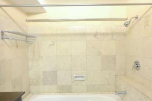 a bathroom with a tub and a shower stall at Modern Look 3BR at Apartment Braga City Walk By Travelio in Bandung +13 photos