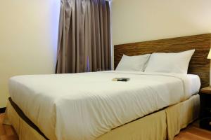 a bedroom with a large bed with white sheets at Modern Look 3BR at Apartment Braga City Walk By Travelio in Bandung