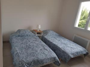 two beds sitting next to each other in a bedroom at villa soleil in Ruoms