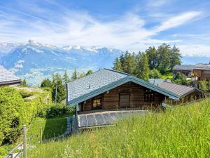 une cabane en rondins avec des montagnes en arrière-plan dans l'établissement Chalet Dorine by Interhome, à Nendaz
