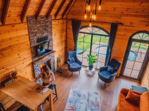 a woman sitting at a table in a room with a fireplace at Sapanca Kırsal Silence in Sapanca