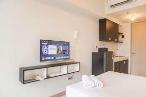 ein Wohnzimmer mit einem Flachbildfernseher an der Wand in der Unterkunft Comfortable and Well Design Studio Tokyo Riverside PIK 2 Apartment By Travelio in Rawalembang