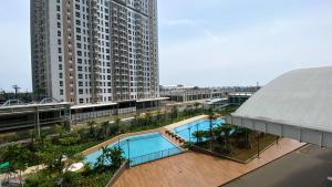 einen Blick über ein großes Gebäude mit Pool in der Unterkunft Comfortable and Well Design Studio Tokyo Riverside PIK 2 Apartment By Travelio in Rawalembang