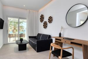 a living room with a black couch and a mirror at Elia Mykonos Resort in Elia Beach