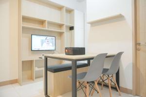 a room with a desk with two chairs and a television at Comfort and Relaxing 2BR (No Kitchen) Tokyo Riverside PIK 2 Apartment By Travelio in Rawalembang