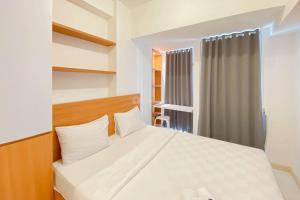 Un dormitorio con una cama blanca y una ventana. en Pleasurable and Tidy Studio at Tokyo Riverside PIK 2 Apartment By Travelio, en Rawalembang 12 fotos más