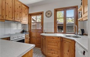 a kitchen with wooden cabinets and a clock on the wall at Awesome Home In Højby With Wifi in Højby