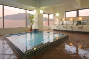 a large swimming pool in a room with windows at Hotel Sunshine Tokushima in Tokushima