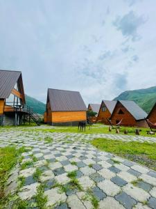 a group of buildings with mountains in the background at Guesthouse Elli & Cottages in Stepantsminda