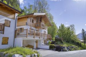 une maison avec un balcon sur le côté dans l'établissement Schöneben Chalet Waldblick, à Wald im Pinzgau