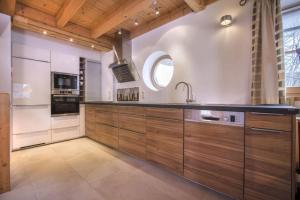 une cuisine avec des armoires en bois et un évier dans l'établissement Schöneben Chalet Waldblick, à Wald im Pinzgau