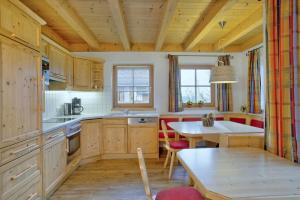 a kitchen with wooden cabinets and a table and a dining room at Schöneben Chalet 4-Jahreszeiten in Wald im Pinzgau