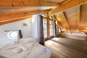 une chambre avec deux lits dans une pièce avec des plafonds en bois dans l'établissement Schöneben Chalet Vienna, à Wald im Pinzgau 28 autres photos