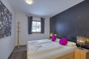 - une chambre avec un grand lit et des oreillers violets dans l'établissement Schöneben Chalet Ferienwelt, à Wald im Pinzgau 26 autres photos