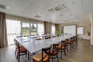 een grote kamer met een lange tafel en stoelen bij Brit Hotel Saint-Méen-le-Grand en Brocéliande in Saint-Onen-la-Chapelle