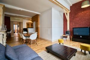 a living room with a couch and a table at Old Lille charming duplex apartment in Lille