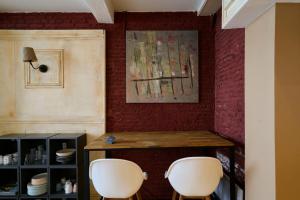 a dining room with two white chairs and a table at Old Lille charming duplex apartment in Lille