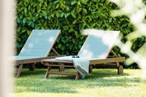 dos sillones vacíos sentados en el césped en Villa avec piscine Domaine des Fées à 100 m plage, en Vaux-sur-Mer