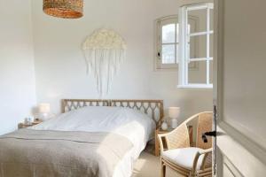 Un dormitorio con una cama, una silla y una ventana en Villa avec piscine Domaine des Fées à 100 m plage, en Vaux-sur-Mer