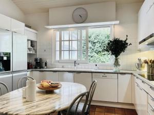Una cocina con una mesa y un reloj en la pared. en Villa avec piscine Domaine des Fées à 100 m plage, en Vaux-sur-Mer 19 fotos más