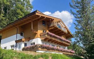 une maison avec un balcon au sommet d'une colline dans l'établissement Schöneben Appartementen Top 1, à Wald im Pinzgau 13 autres photos