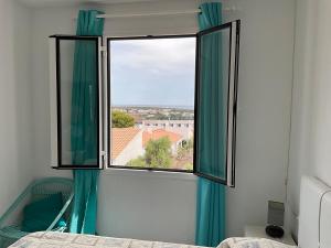 Un dormitorio con una ventana con cortinas verdes y una cama en Vistas al mar y la piscina, en Arenal d'en Castell 20 fotos más