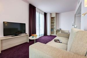 TV a/nebo společenská místnost v ubytování Brit Hotel Vendée Mer