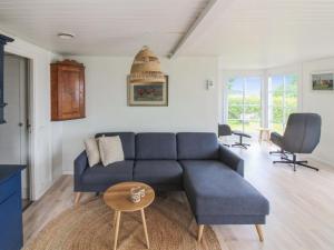 a living room with a blue couch and a table at Holiday Home Fabine - 50m from the sea by Interhome in Allinge