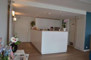 a woman standing behind a counter in a kitchen at Brit Hotel Les Alizes in Pornic