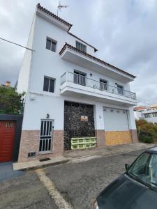 a white house with a car parked in front of it at Casa Sara 2 in Icod de los Vinos