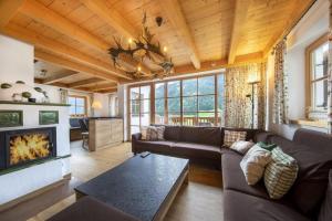 a living room with a couch and a fireplace at Schöneben Chalet Holzblick in Wald im Pinzgau