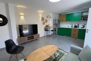 a living room with a couch and a tv and a table at Benemanuel Oasis in Beer Sheva