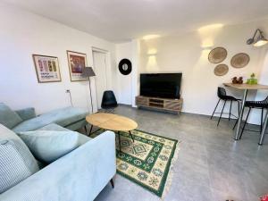 a living room with a couch and a tv and a table at Benemanuel Oasis in Beer Sheva