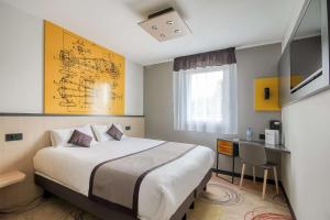 a hotel room with a bed and a desk at Brit Hotel Le Cottage Le Mans Sud in Arnage