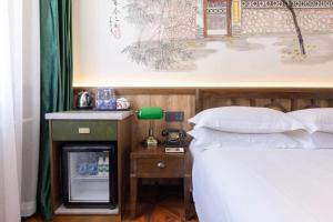 Postel nebo postele na pokoji v ubytování Nost algia Hotel Near Beijing Panjiayuan Antique Market- Beijing Happy Valley, CBD, China Zun and Sanlitun, Tian'anmen Square, Free ice cream, mineral water, coffee, snacks and laundry service, Free gymnastic, English communication well