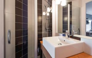 a bathroom with a white sink and a shower at Brit Hotel de Paris Saint-Jean-de-Luz in Saint-Jean-de-Luz