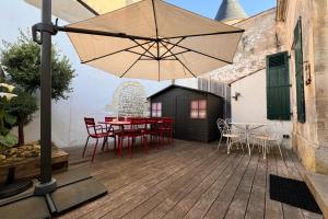 a patio with a table and chairs and an umbrella at Maison Ferry - Welkeys in Rivedoux-Plage