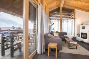 un salon avec un canapé et une grande fenêtre dans l'établissement Schöneben Chalet Anne Marie, à Wald im Pinzgau