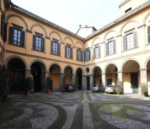 a large building with cars parked in a courtyard at Antica Dimora in Bergamo