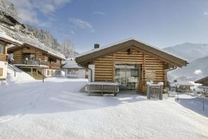 une cabane en rondins avec de la neige à l'avant dans l'établissement Schöneben Traumhütte, à Wald im Pinzgau