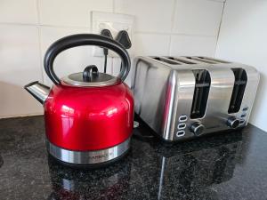 a red tea kettle is next to a toaster at Riverview House Sedgefield in Sedgefield