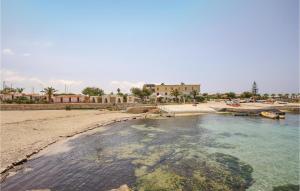 a body of water with a beach and a building at 4 Bedroom Cozy Home In Custonaci in Custonaci