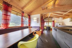 une cuisine avec une table en bois et des chaises jaunes dans l'établissement Schöneben Chalet Anton, à Wald im Pinzgau