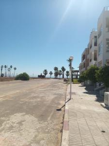 Una calle vacía con palmeras y una farola. en Cosy appartement Front de mer - Marina Studio, en Marina Smir 4 fotos más