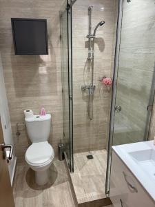 a bathroom with a shower and a toilet and a television at Marrakech Golf City Prestigia 4 minutes du centre in Marrakech