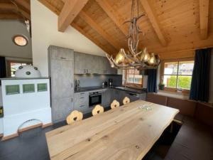 a large kitchen with a wooden table and a chandelier at Schöneben Chalet MiJoBa in Wald im Pinzgau